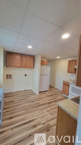 A kitchen with wooden floors and white appliances.