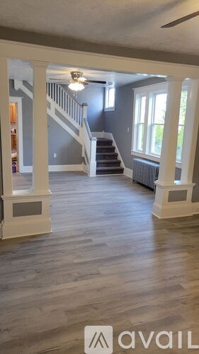 A spacious living room with a staircase leading to the upper floor.