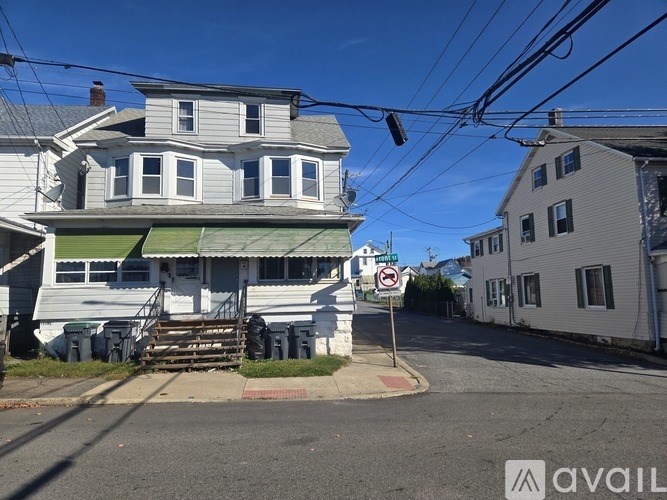 A street view with a house and a sign that says "No Parking".