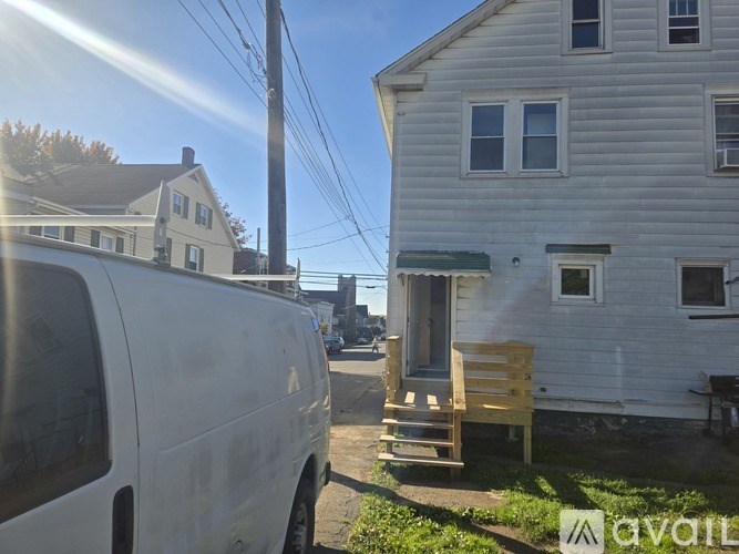 A white van is parked on a driveway in front of a house.