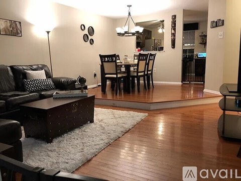 A living room with a black couch and a wooden coffee table.