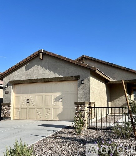 A house with a garage door and a black fence.