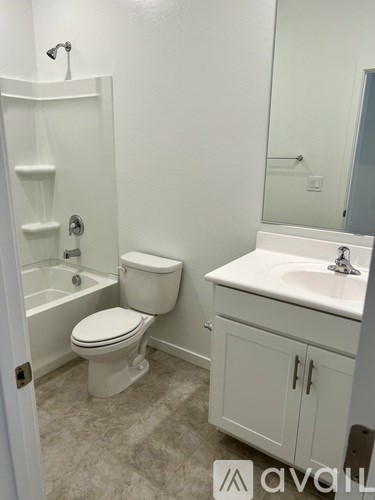 A white toilet with a white sink and a white cabinet in a bathroom.