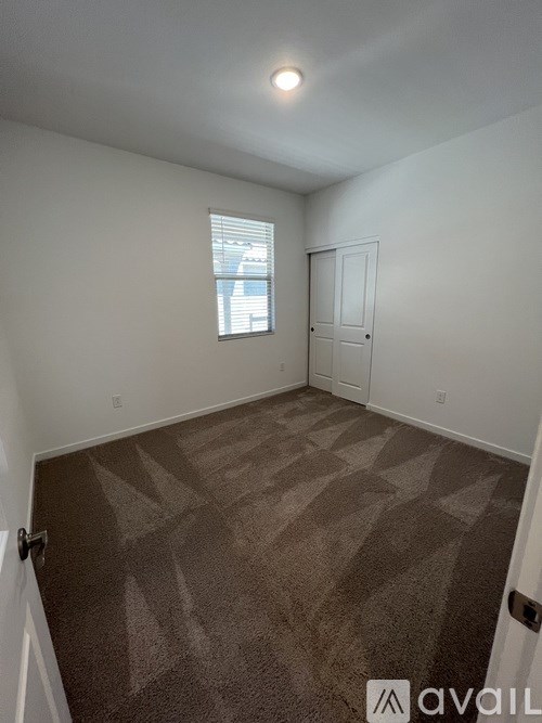 A room with a carpeted floor and a window.
