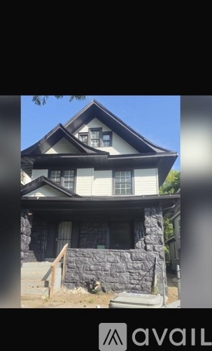 A house with a stone wall in front.