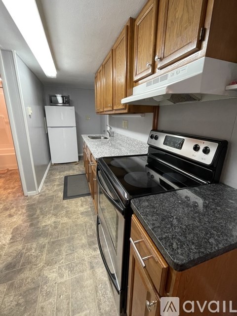 A kitchen with a stove top oven and a refrigerator.