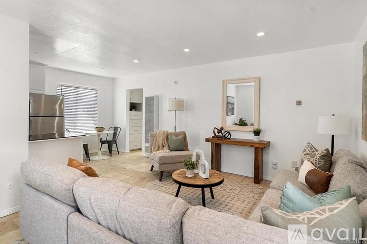 A living room with a grey sofa and a wooden coffee table.