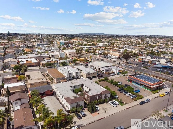A bird's eye view of a city with buildings, cars, and a clear sky.
