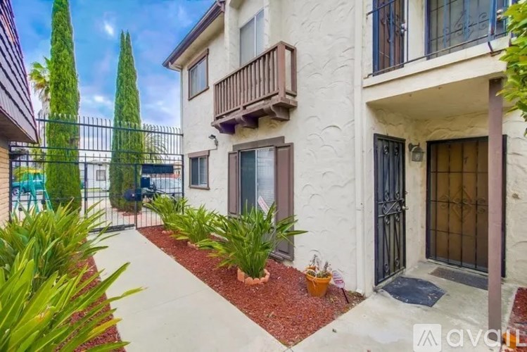 A white building with a balcony and a gate.