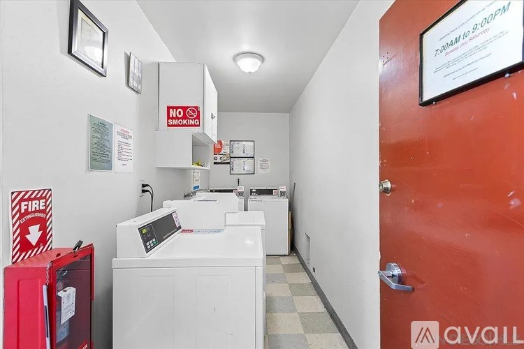 A laundry room with a washer and dryer, a fire extinguisher, and a no smoking sign.