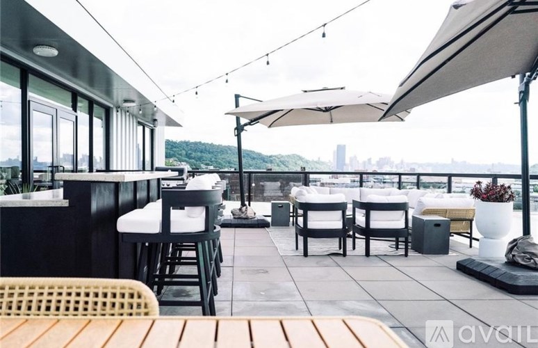 A patio with tables and chairs is covered with a white umbrella.