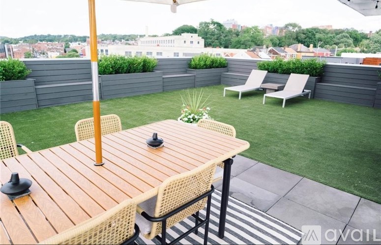 A modern kitchen with a wooden floor and a black fridge.