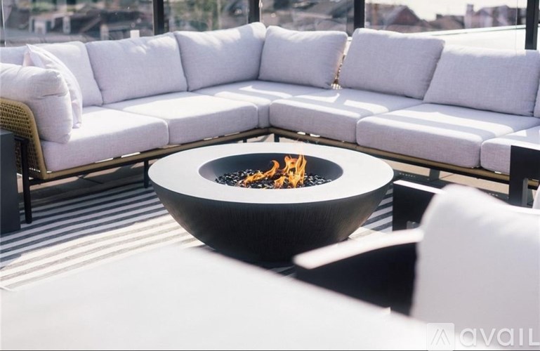 A modern outdoor seating area with a fire pit in the center.