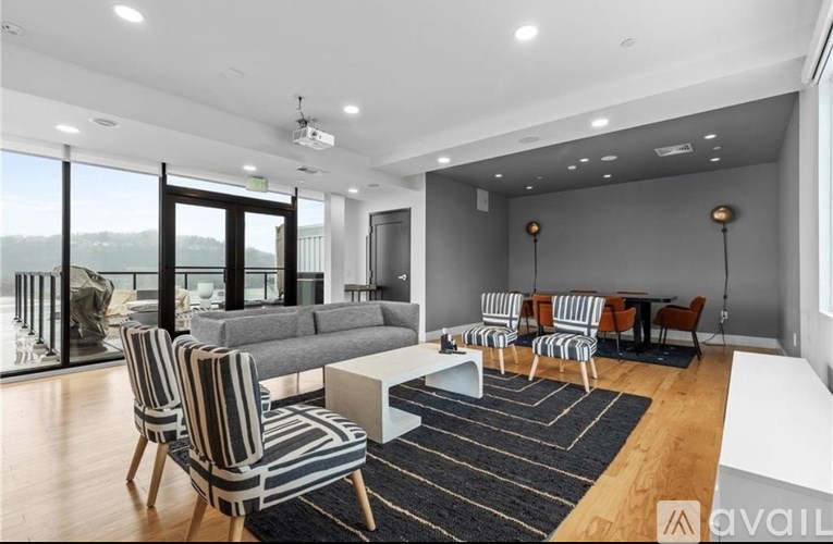 A living room with a striped chair and a grey couch.