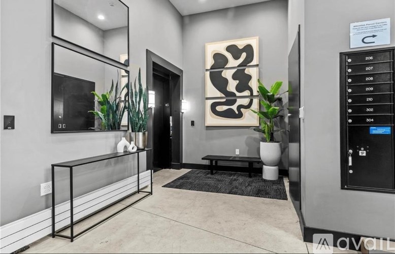 A modern hallway with a black and white artwork on the wall.