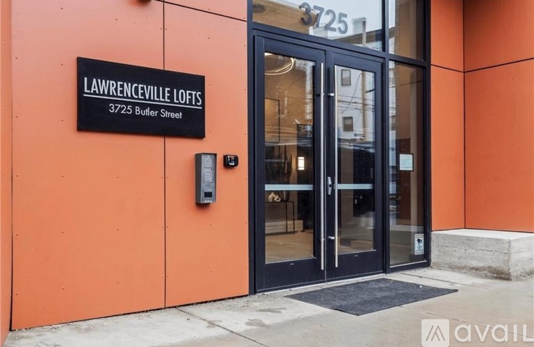 The entrance to Lawrenceville Lofts is shown with a black door and a sign above it.