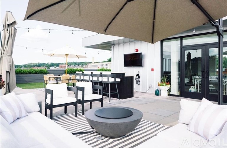 A patio with a table and chairs under a large umbrella.