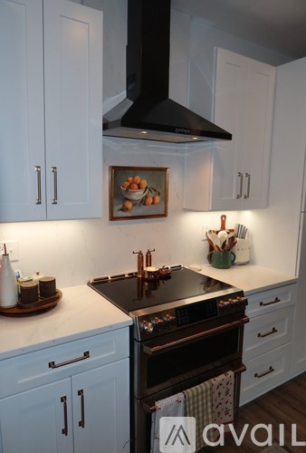 A kitchen with a black stove top oven and white cabinets.