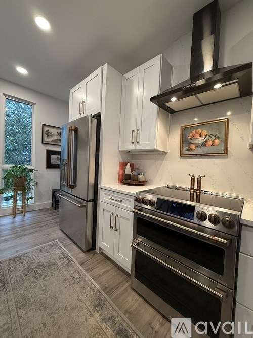 A small table with two chairs and a vase of flowers sits in front of a window.