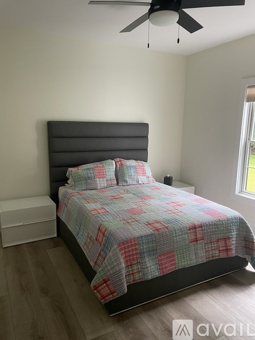 A bedroom with a bed and a ceiling fan.