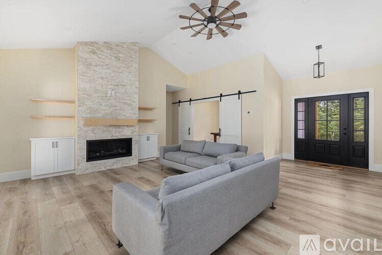A living room with a grey couch and a fireplace.