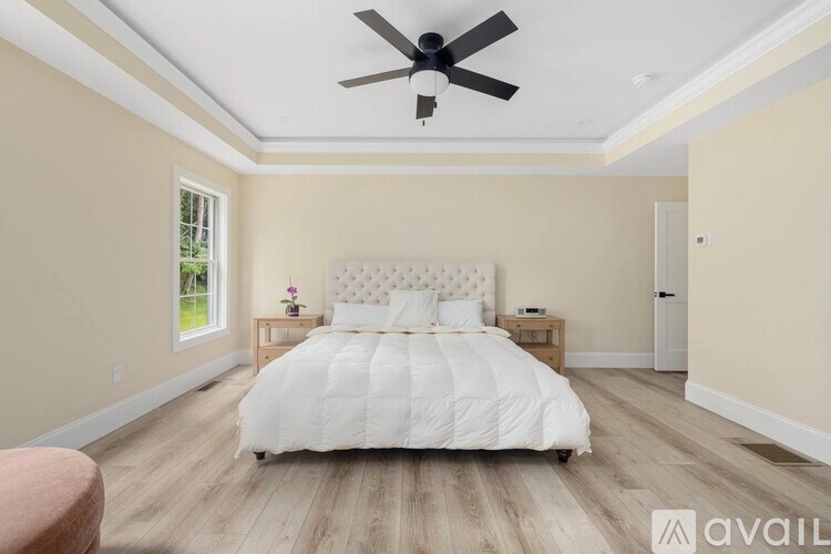 A bedroom with a large bed and a ceiling fan.