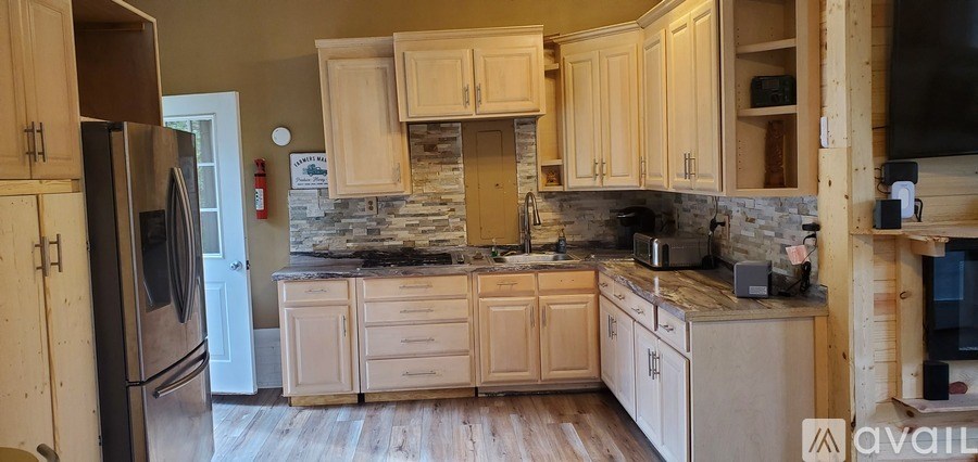 A kitchen with wooden cabinets and a stone backsplash.