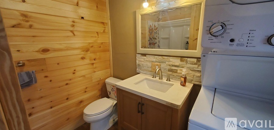 A small bathroom with a toilet, sink and a washing machine.