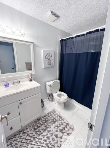 A bathroom with a toilet, sink, and shower.