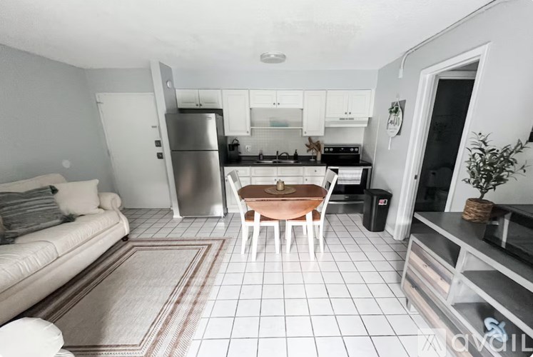 A kitchen with a refrigerator, stove, and sink.