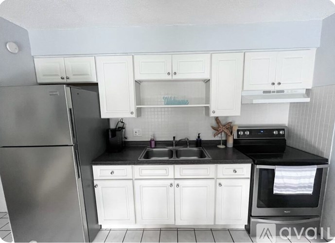 A kitchen with white cabinets and black appliances.