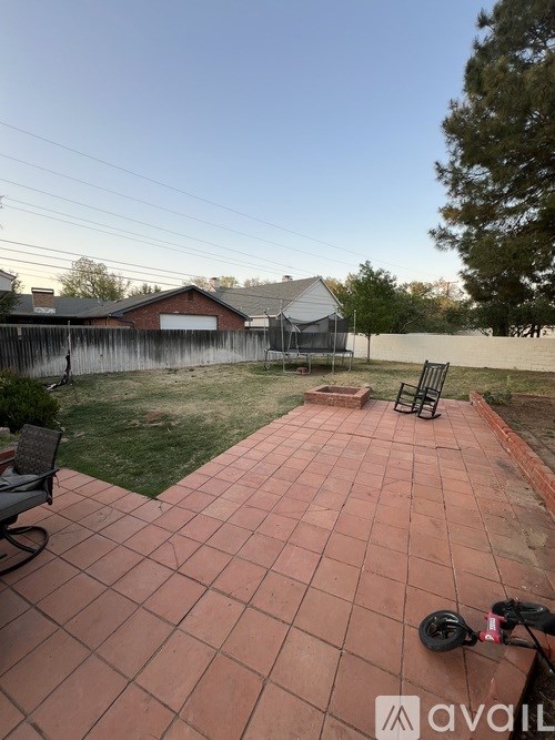 A patio with a table and chairs is in the foreground of a backyard.