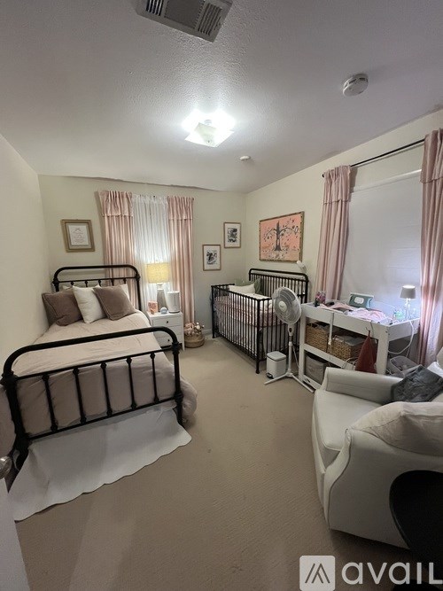 A bedroom with a large bed and a crib.