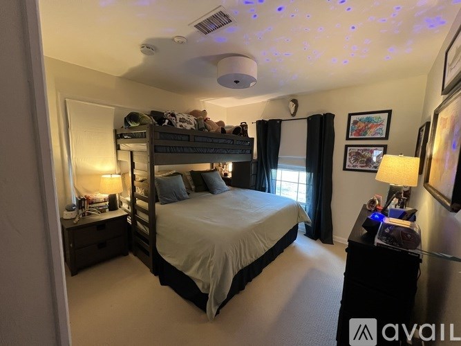 A bedroom with a bed, nightstands, and a ceiling fan.