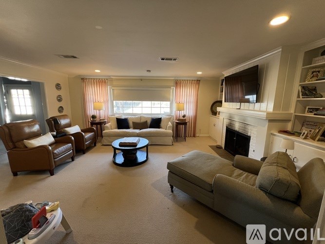 A living room with a fireplace and a grey couch.