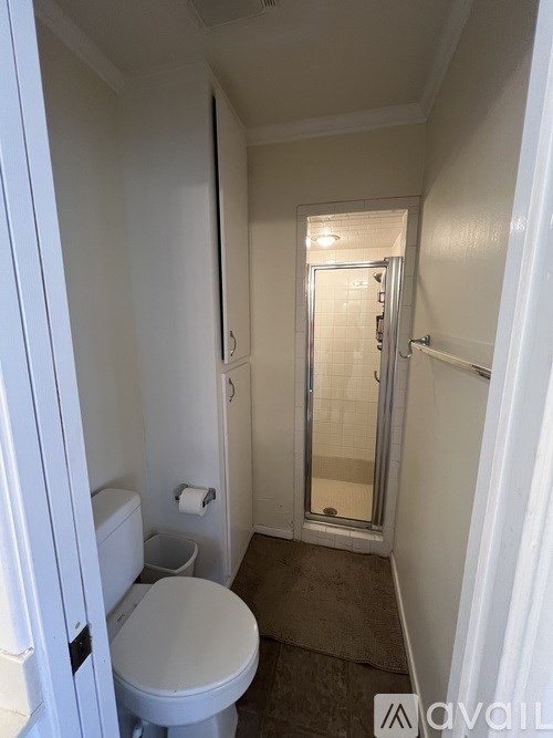 A small bathroom with a toilet, sink, and shower.