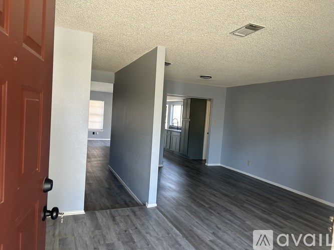 A room with a red door and grey walls is available for rent.