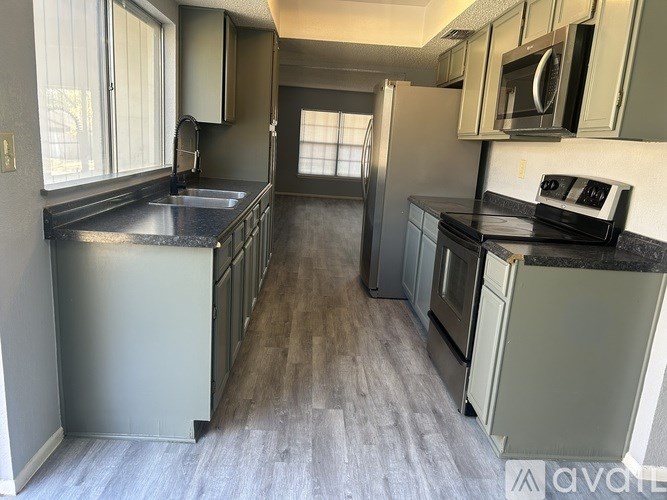 A kitchen with a refrigerator, sink, and oven.