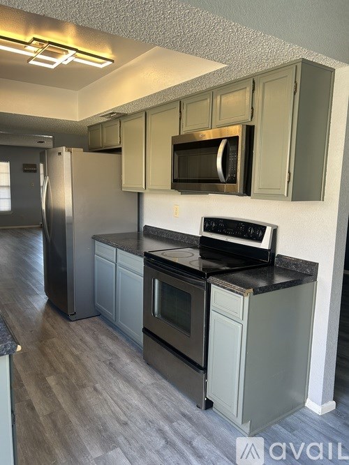 A kitchen with a black counter top and a black oven.
