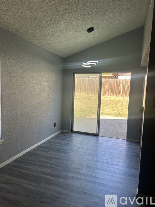 A room with a sliding glass door leading to a backyard.