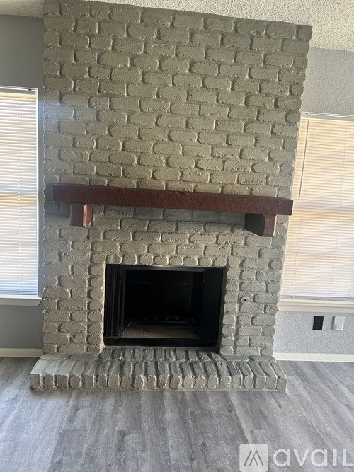 A fireplace with a brick design and a wooden mantle.
