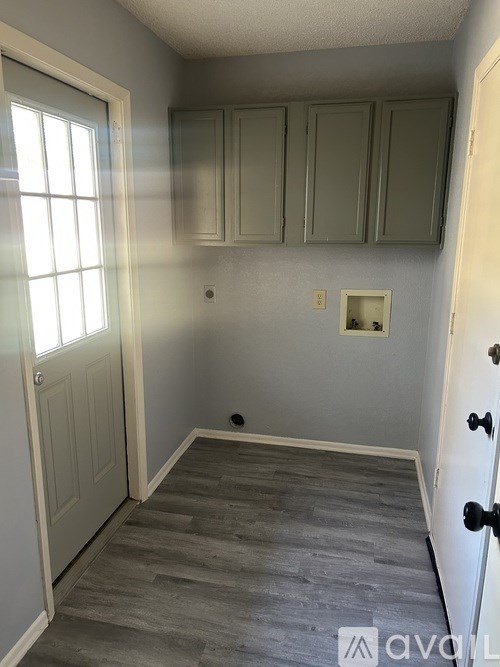 A room with grey cabinets and a grey floor.