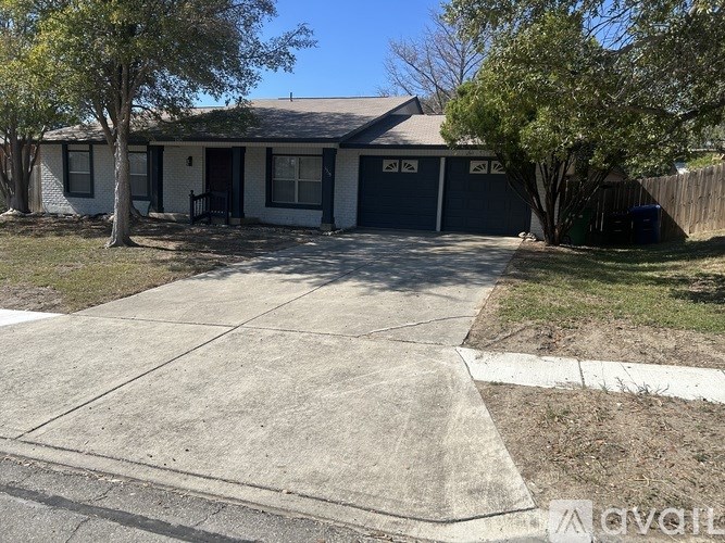 A house with a driveway and a tree in front.