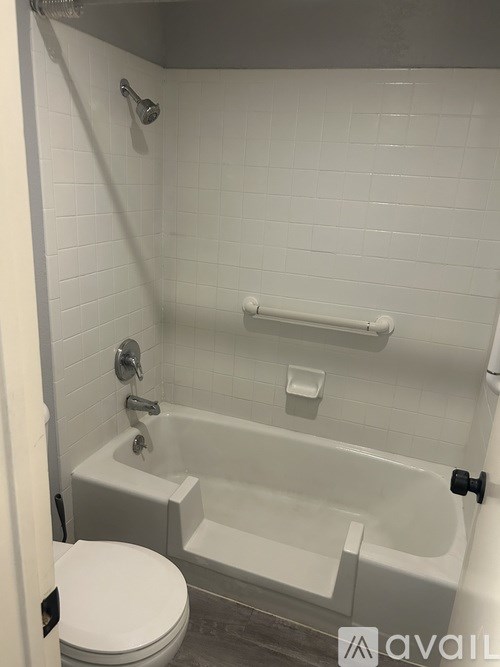 A white toilet is next to a bathtub in a bathroom.