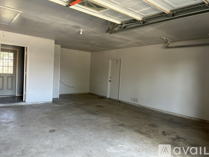 A large empty room with a door and a window.