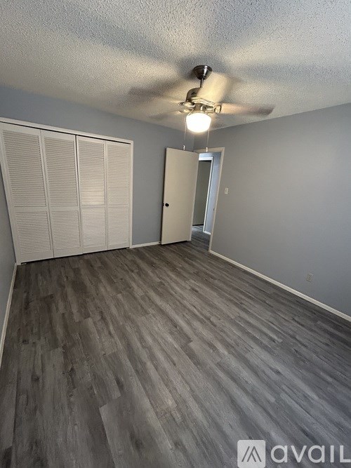 A room with a ceiling fan and sliding doors.