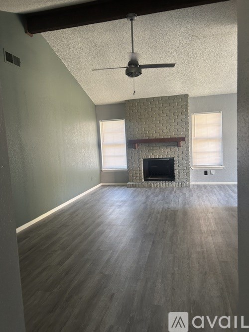 A room with a fireplace and a ceiling fan.