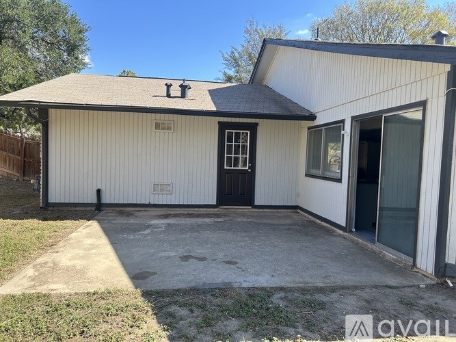 A white house with a black door and a small porch.