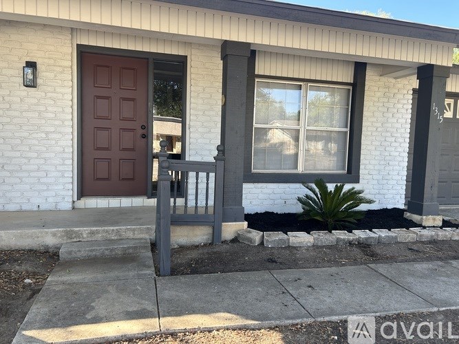 A house with two garage doors and a tree in front.