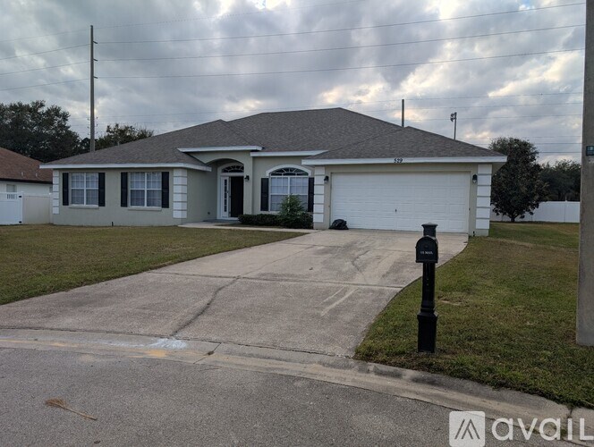 A house with a grey roof and a white garage door is shown.